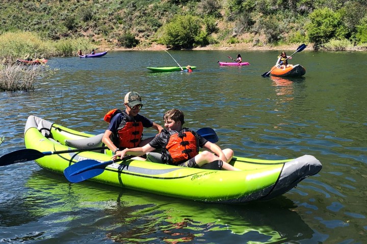 a group of people riding on the back of a boat in the water
