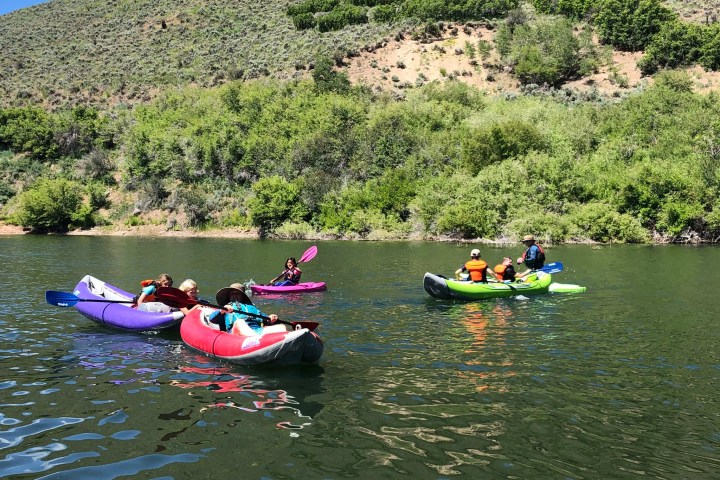 a group of people riding on the back of a boat in the water
